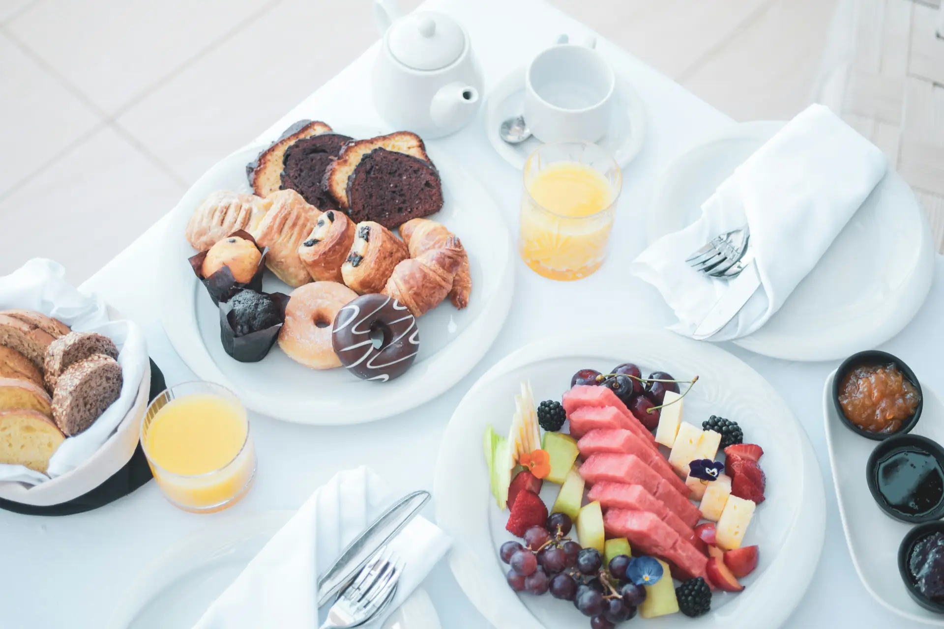 A hotel breakfast spread of pastries, fruit and juice